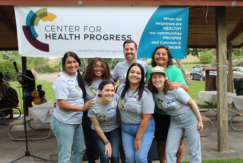 Center for Health Progress staff pose outdoors under CHP banner