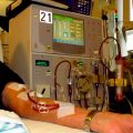 An arm is hooked up to a dialysis machine in a patient room