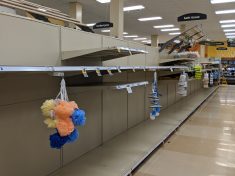 Empty grocery store shelves with loofahs hanging in front