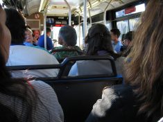 Public transportation inside a crowded bus with several backs of heads